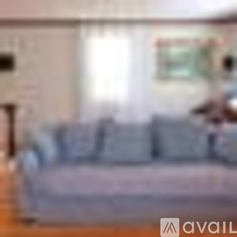 A couch in a living room with a person sitting on it.