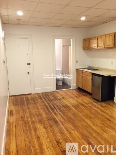 A kitchen with wooden floors and white walls.