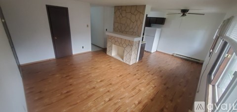 A room with wooden flooring and a ceiling fan.