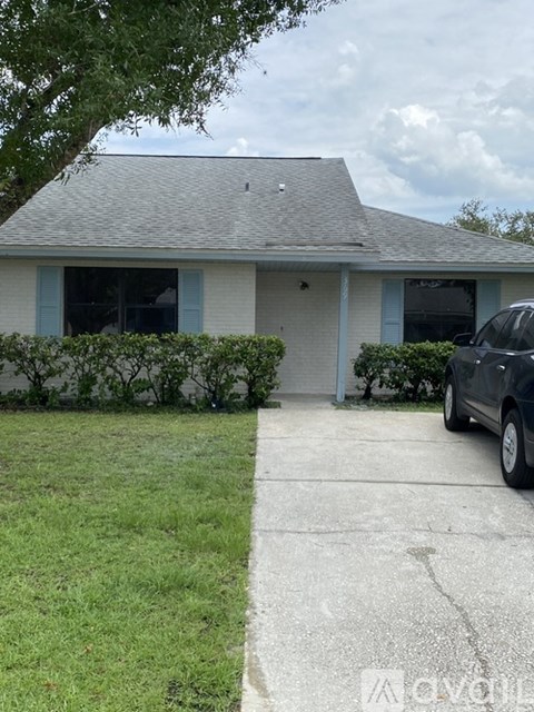 A house with a car parked in front.