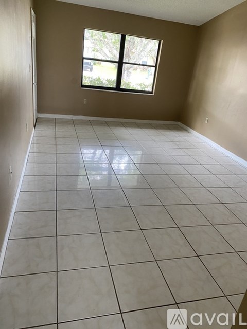 A room with a large tiled floor and a window.