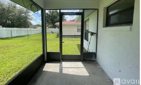 A patio with a sliding door leading to a grassy area.
