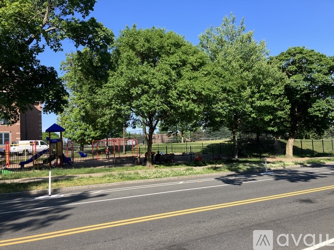 A playground with a slide and swings is surrounded by trees.