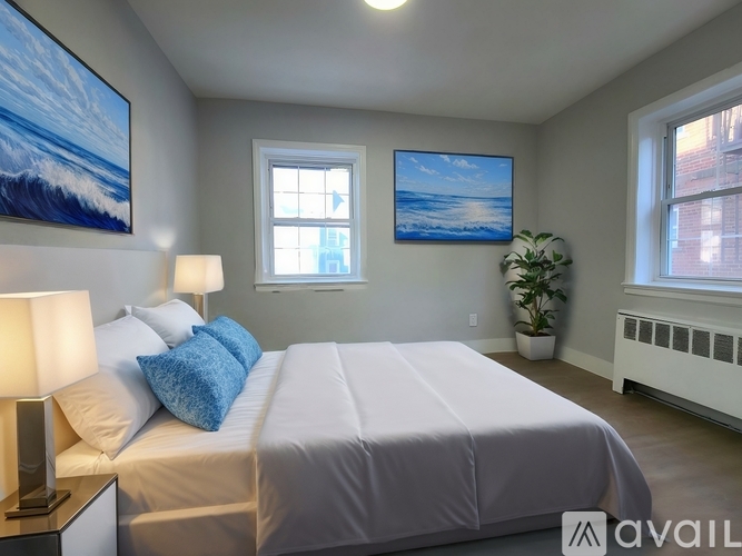 A bedroom with a large bed and two pictures on the wall.