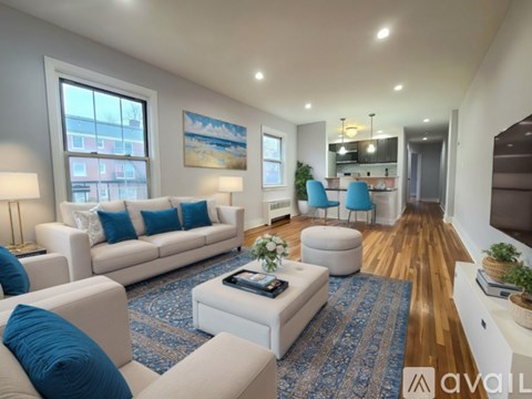 A living room with a white couch and blue pillows.
