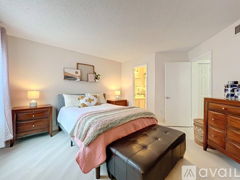 A bedroom with a bed, nightstands, and a bench.