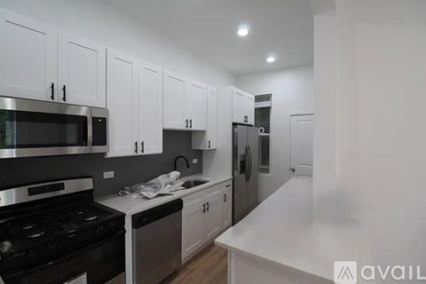 A kitchen with white cabinets and black appliances.