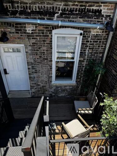 A small balcony with a table and chairs.