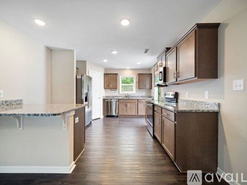 A kitchen with brown cabinets and a granite countertop.