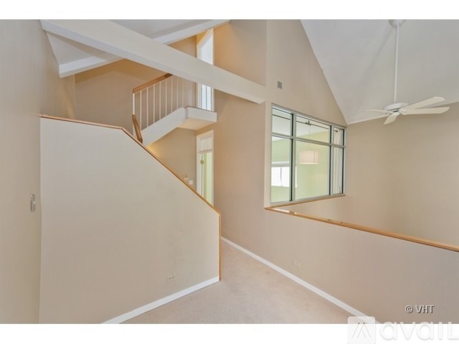 A spacious room with a staircase and a window.