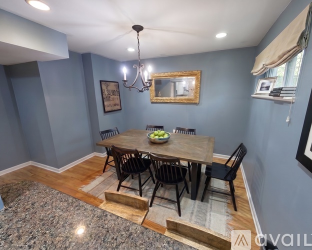 A dining room with a wooden table and chairs.