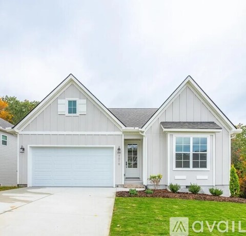A two-story house with a garage and a driveway.