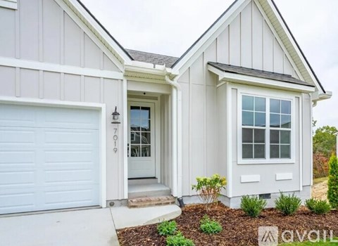 A house with a white garage door and a window.