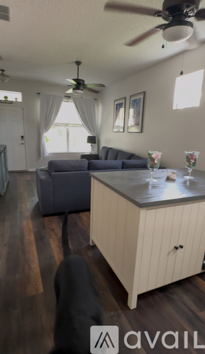 A living room with a grey couch and a wooden cabinet.