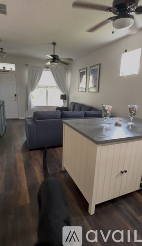 A living room with a grey couch and a wooden cabinet.