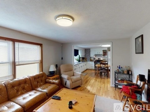 A living room with a brown leather couch and a wooden coffee table.