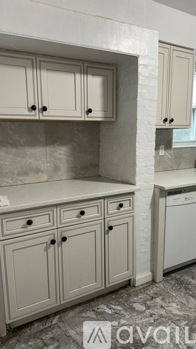 A kitchen with white cabinets and a washing machine.