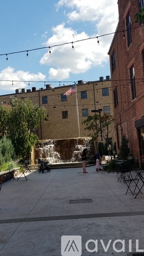 A courtyard with a fountain and a flag on a building.