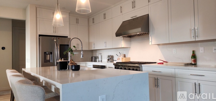 A kitchen with a blue island and white cabinets.