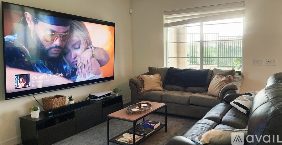 A living room with a large TV displaying a movie scene.