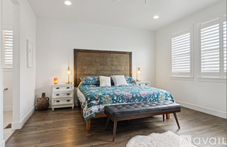 A bedroom with a large bed and a wooden headboard.
