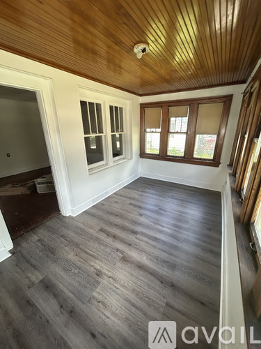 A room with wooden floors and a ceiling with wooden beams.