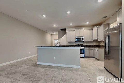 A kitchen with a white island and stainless steel appliances.