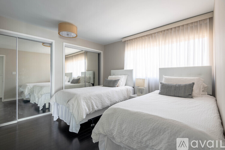 A bedroom with two beds and a mirror.