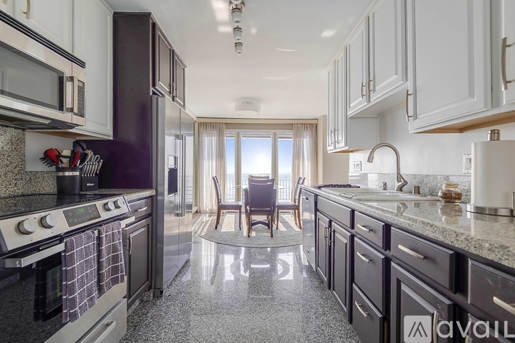 A kitchen with black cabinets and a granite countertop.