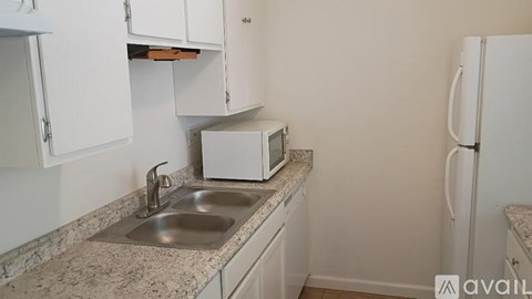 A kitchen with a sink and a refrigerator.