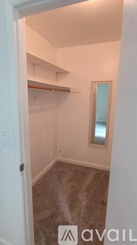 A small, empty room with a mirror on the wall.