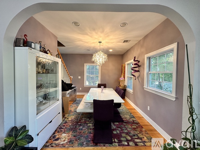 A dining room with a white table and chairs.