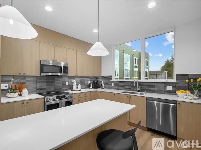 A modern kitchen with wooden cabinets and a large island.