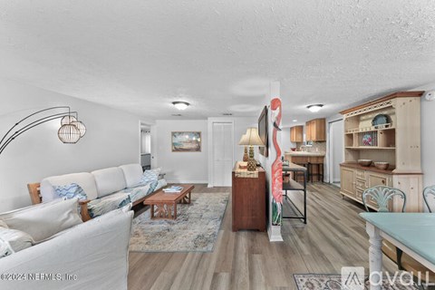 A living room with a white couch and a wooden coffee table.