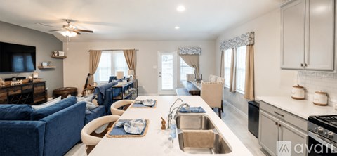 A modern kitchen with a blue sofa in the living room.