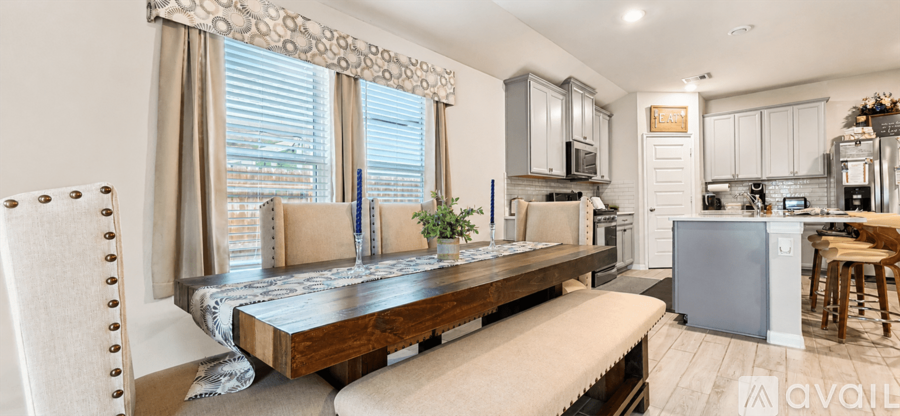 A kitchen with a table and chairs in front of a window.