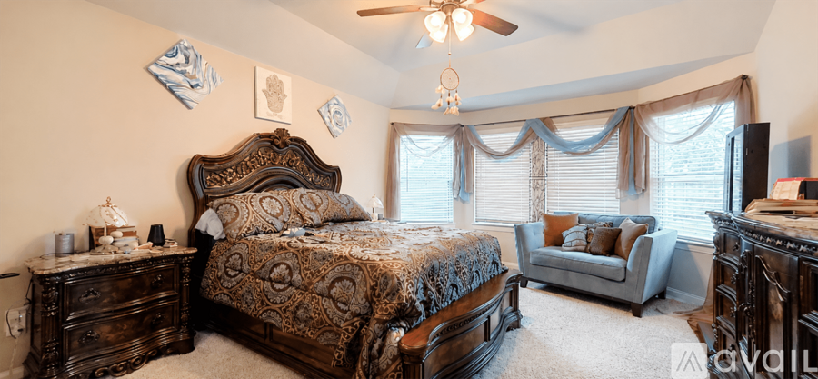 A bedroom with a large bed and a ceiling fan.