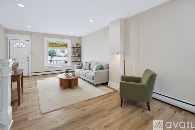 A living room with a white couch, a green armchair, and a wooden coffee table.
