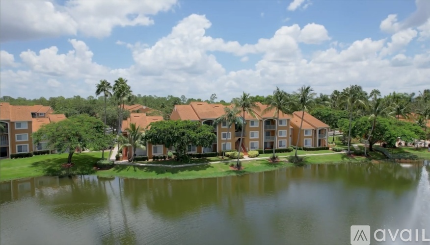 A large building complex with a pond in front of it.