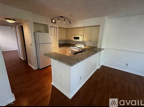 A kitchen with a granite countertop and white cabinets.