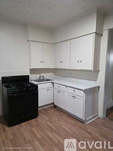 A black stove is in a kitchen with white cabinets.