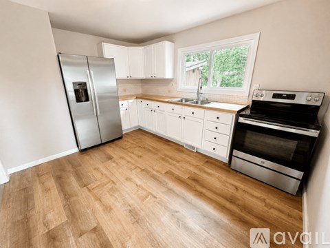 A kitchen with a refrigerator, oven, and sink.
