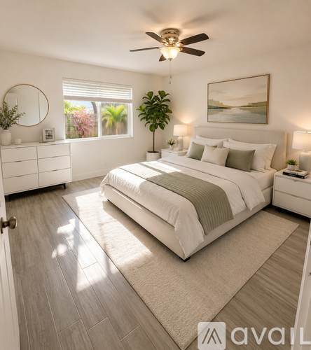 A well-lit bedroom with a large bed and a ceiling fan.