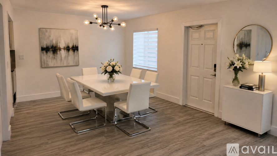 A dining room with a white table and chairs.