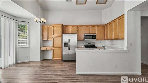 A kitchen with wooden cabinets and a white island.