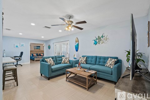 A living room with a blue couch and a wooden coffee table.