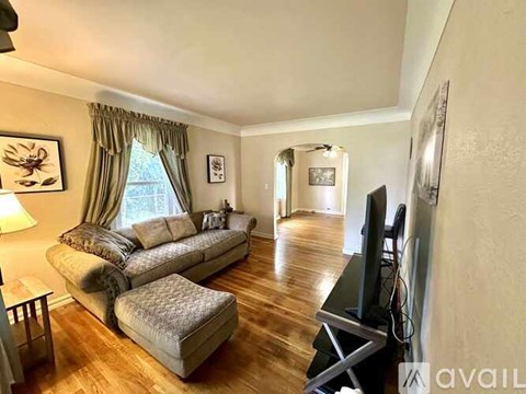 A living room with a grey couch and a television.