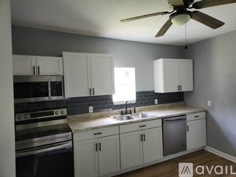 A kitchen with white cabinets and a black stove top oven.
