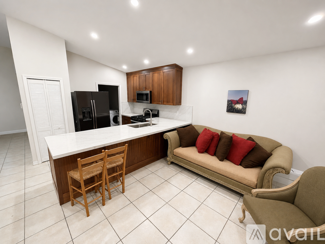 A kitchen with a couch and a fridge.