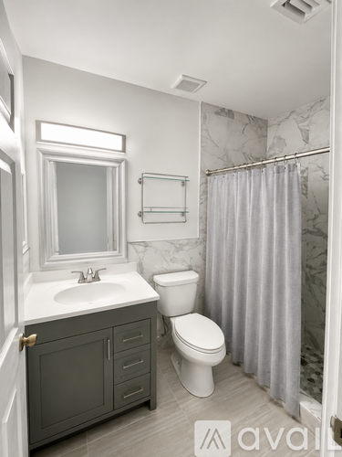 A bathroom with a toilet, sink, and shower.